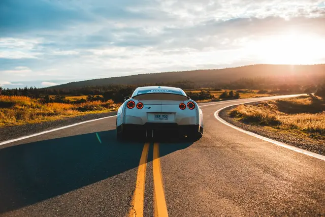Sports car on an open road at sunset